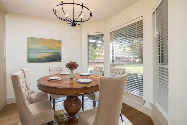 dining space with wood-type flooring and an inviting chandelier