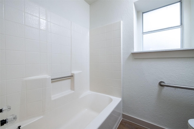 bathroom with bathing tub / shower combination and hardwood / wood-style flooring