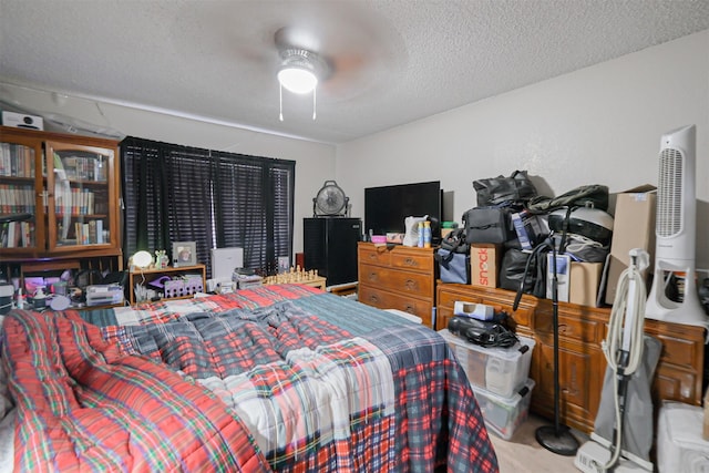 bedroom with ceiling fan, light colored carpet, and a textured ceiling