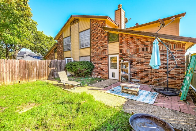 rear view of property with a lawn and a patio area