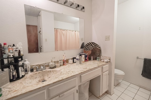 bathroom with tile patterned flooring, vanity, and toilet