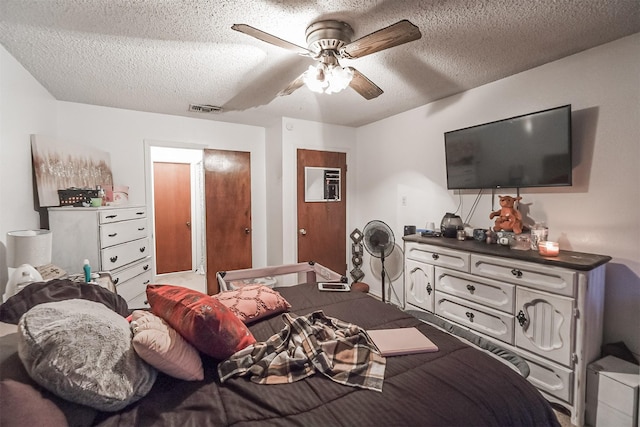 bedroom featuring ceiling fan and a textured ceiling