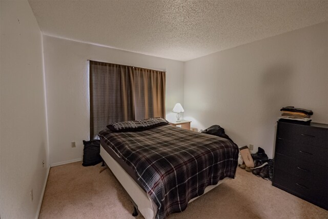 bedroom with light carpet and a textured ceiling