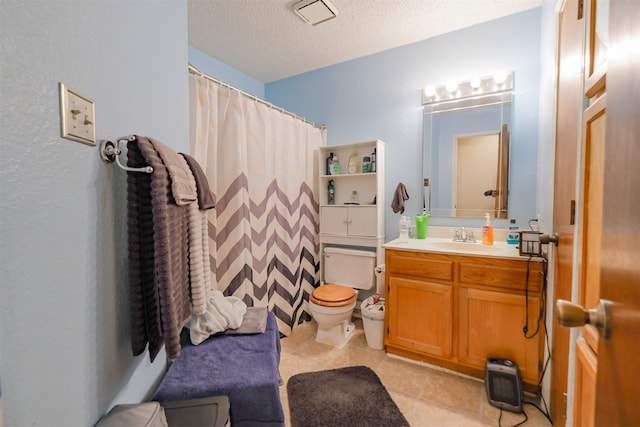 bathroom with tile patterned flooring, vanity, toilet, and a textured ceiling