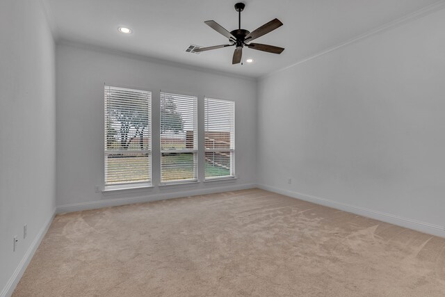 carpeted empty room with ceiling fan and crown molding