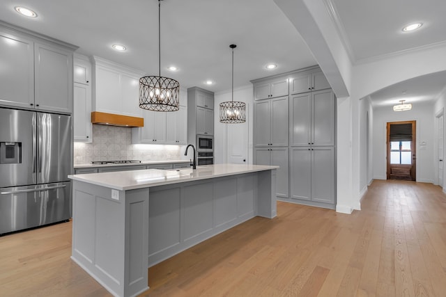 kitchen featuring gray cabinetry, stainless steel appliances, light hardwood / wood-style flooring, crown molding, and pendant lighting