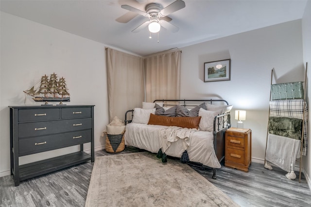 bedroom with dark hardwood / wood-style flooring and ceiling fan