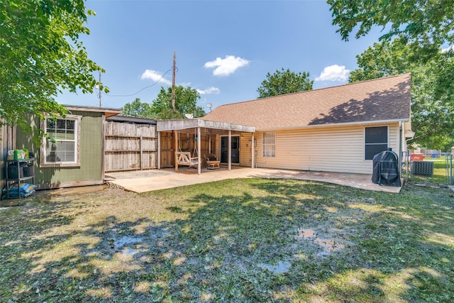 back of property with a yard and a patio