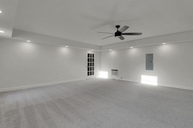 spare room featuring carpet, a wall mounted air conditioner, electric panel, and ceiling fan