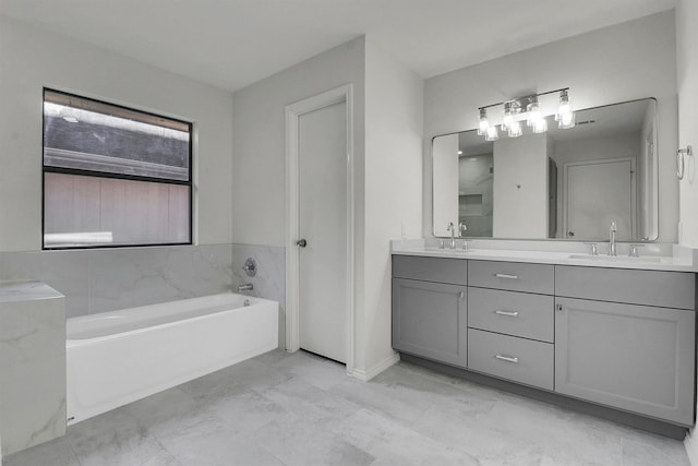 bathroom featuring vanity and a washtub