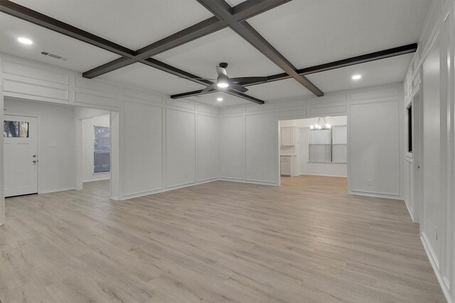 unfurnished living room with beam ceiling, coffered ceiling, ceiling fan with notable chandelier, and light hardwood / wood-style floors