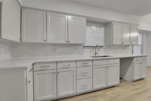 kitchen featuring sink, backsplash, and light wood-type flooring