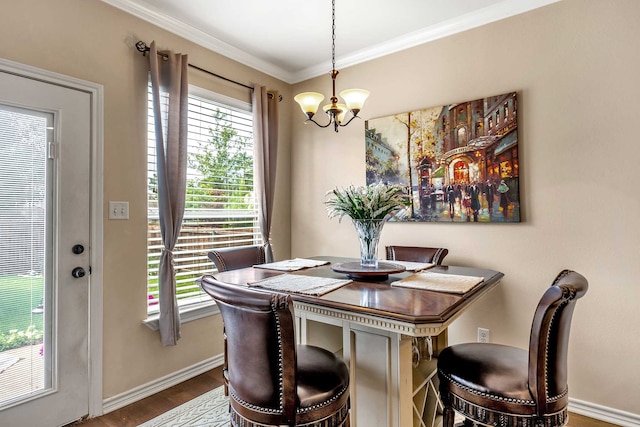 dining area with hardwood / wood-style flooring, an inviting chandelier, and ornamental molding