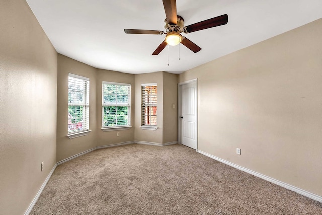 carpeted spare room featuring ceiling fan