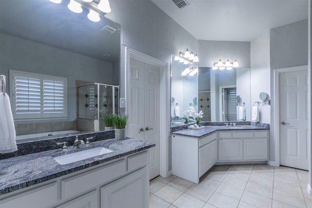 bathroom featuring plus walk in shower, vanity, and tile patterned floors