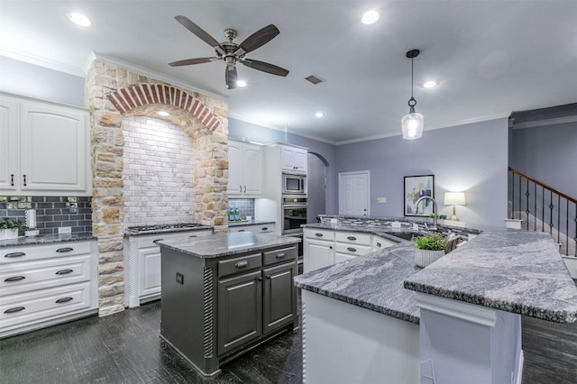 kitchen featuring pendant lighting, white cabinets, sink, appliances with stainless steel finishes, and tasteful backsplash