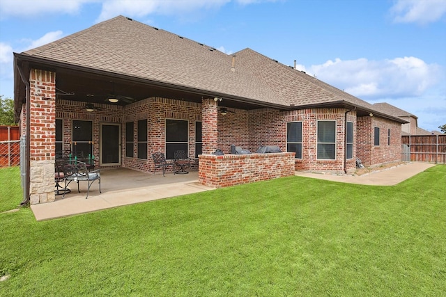 back of property with a yard, a patio, and exterior kitchen