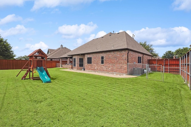 rear view of property with a playground and a lawn