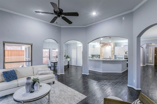 living room featuring dark hardwood / wood-style floors, ceiling fan, and ornamental molding