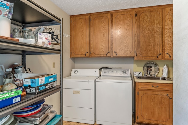 laundry area featuring washing machine and dryer, cabinets, and a textured ceiling