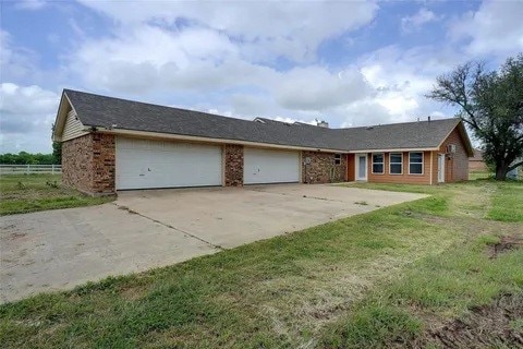 ranch-style home with a front yard and a garage