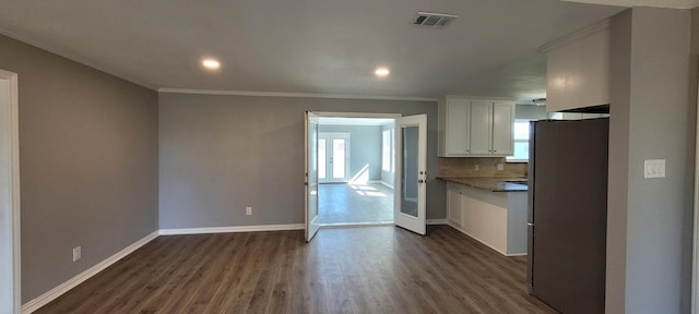 kitchen with stainless steel refrigerator, dark wood-type flooring, crown molding, decorative backsplash, and white cabinets