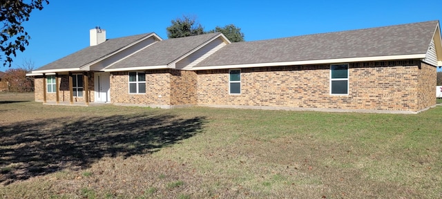 back of property featuring a yard