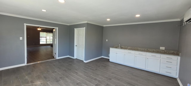 kitchen with crown molding, white cabinetry, dark hardwood / wood-style flooring, and light stone counters