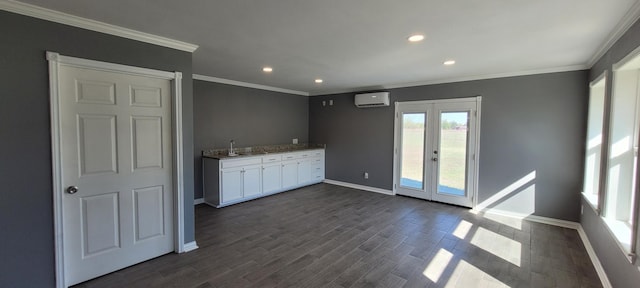 kitchen with french doors, dark hardwood / wood-style flooring, an AC wall unit, crown molding, and white cabinets