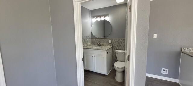 bathroom featuring vanity, tasteful backsplash, and toilet