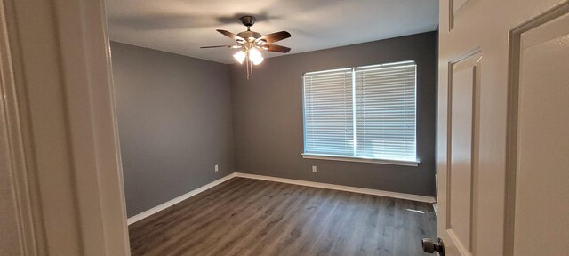 empty room with dark hardwood / wood-style floors and ceiling fan