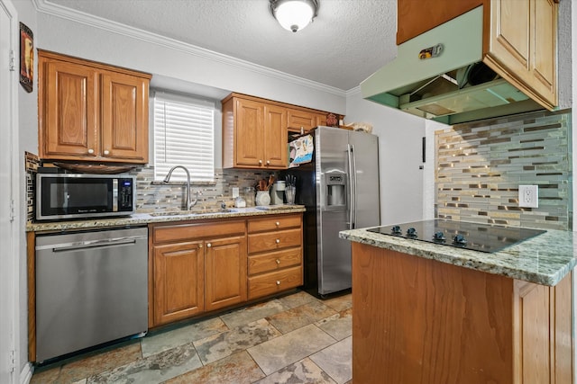 kitchen featuring appliances with stainless steel finishes, tasteful backsplash, light stone counters, a textured ceiling, and sink