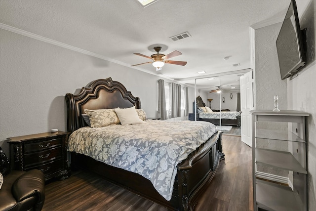 bedroom with a textured ceiling, ceiling fan, crown molding, dark hardwood / wood-style floors, and a closet