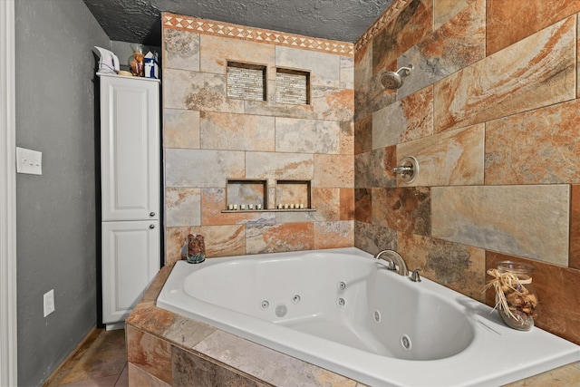 bathroom featuring tile patterned flooring, a textured ceiling, and tiled bath