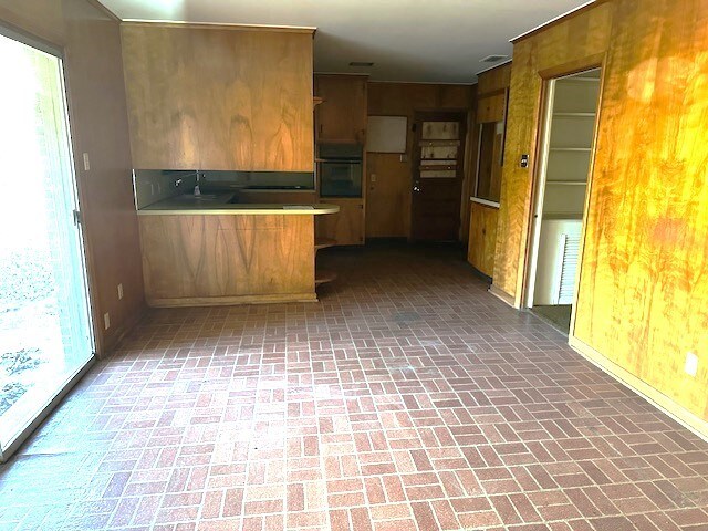 kitchen with black oven, kitchen peninsula, and a healthy amount of sunlight