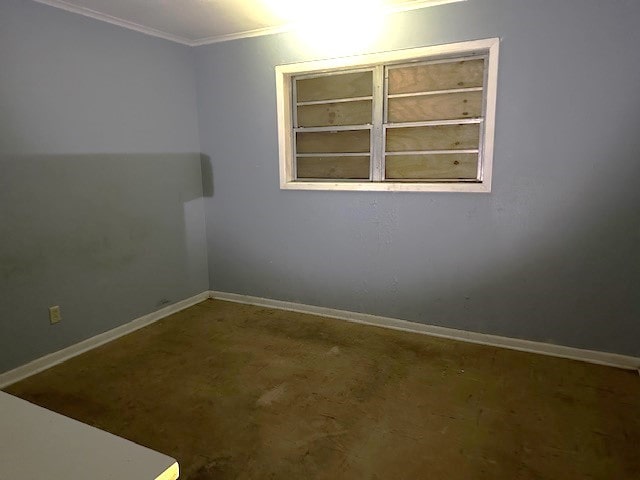 empty room featuring crown molding and concrete flooring