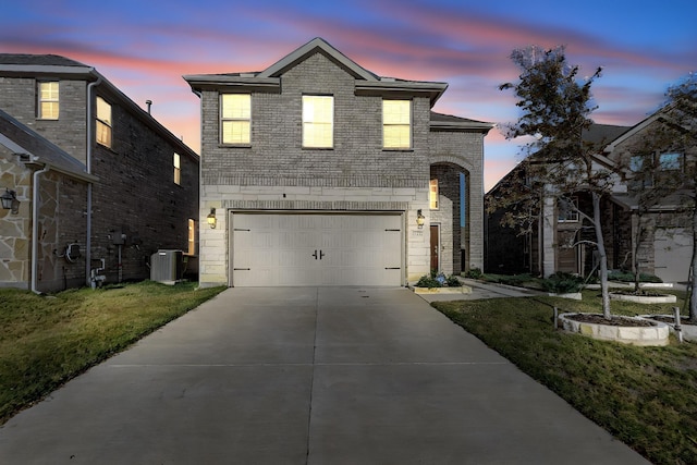 view of front of home with cooling unit, a garage, and a yard