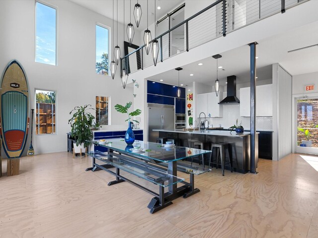 dining space with sink and a towering ceiling