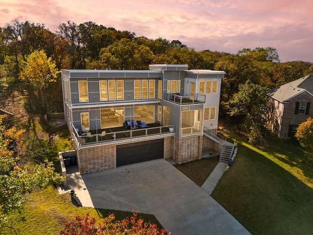 modern home featuring a yard, a balcony, and a garage