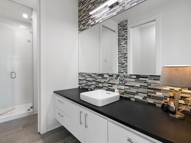 bathroom featuring vanity, an enclosed shower, and decorative backsplash