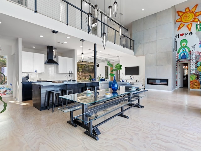 dining area featuring plenty of natural light, a fireplace, and a high ceiling