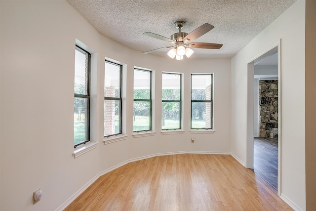 unfurnished room featuring ceiling fan, a healthy amount of sunlight, and light hardwood / wood-style floors