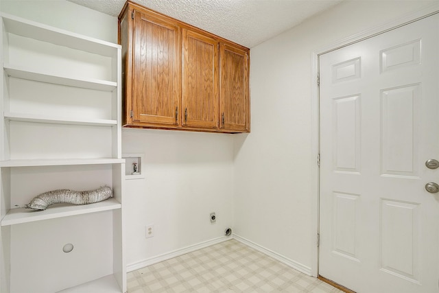 washroom featuring hookup for an electric dryer, cabinets, a textured ceiling, and hookup for a washing machine