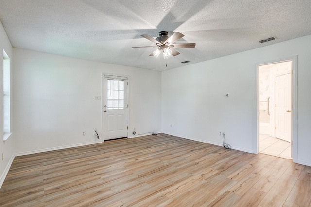 spare room featuring a textured ceiling, light hardwood / wood-style flooring, and ceiling fan