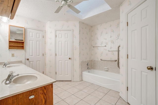 bathroom with ceiling fan, tile patterned floors, a textured ceiling, a bathtub, and vanity