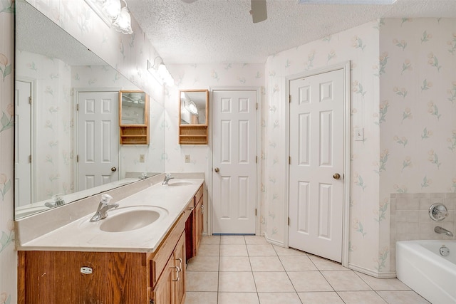 bathroom featuring tile patterned floors, vanity, a bath, and a textured ceiling