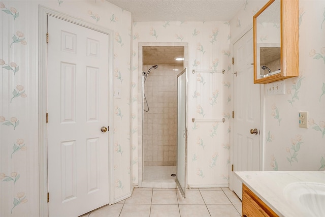 bathroom with vanity, a tile shower, a textured ceiling, and tile patterned floors