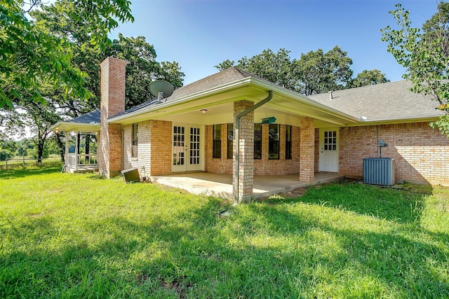 back of property featuring central air condition unit, a yard, and a patio