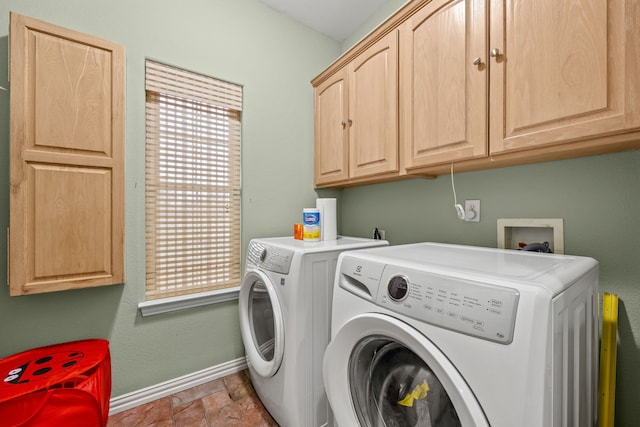 laundry room featuring cabinets, washer and clothes dryer, and a healthy amount of sunlight