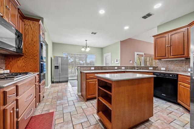 kitchen featuring pendant lighting, an inviting chandelier, black appliances, sink, and a kitchen island